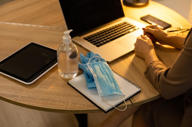 Foto mulher colocando luvas de proteção e máscara no escritório.