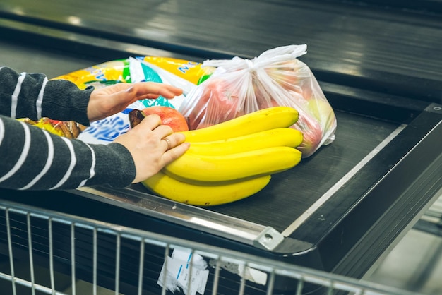 Mulher colocando o produto na fila perto do caixa