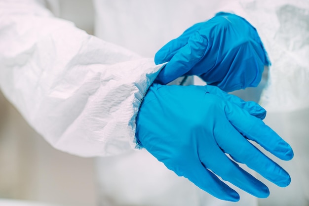 Mulher colocando protetor facial contra respingos em equipamentos de segurança de laboratório