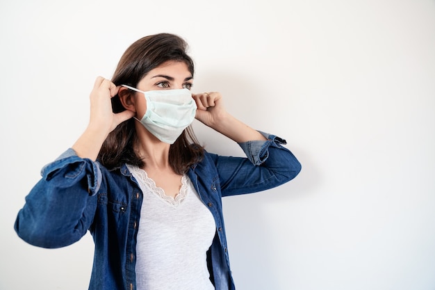 Foto mulher colocando uma máscara protetora médica.