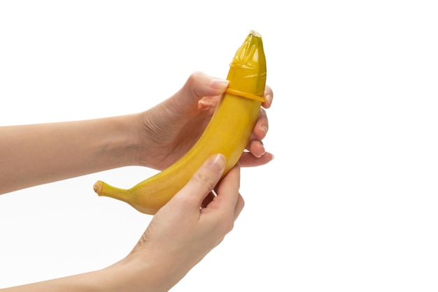 Mulher colocou um preservativo em uma banana isolada no fundo branco