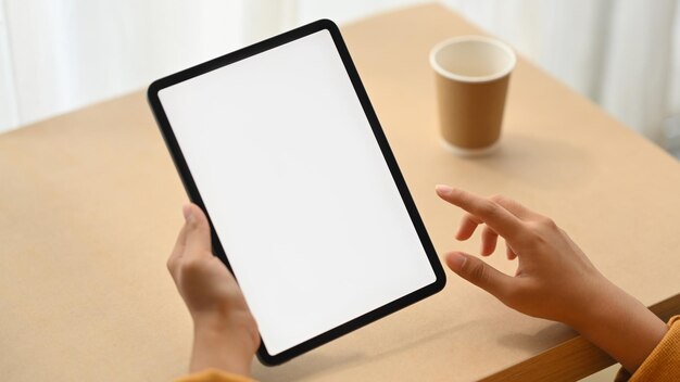 Mulher com a mão segurando um tablet digital com tela branca para publicidade