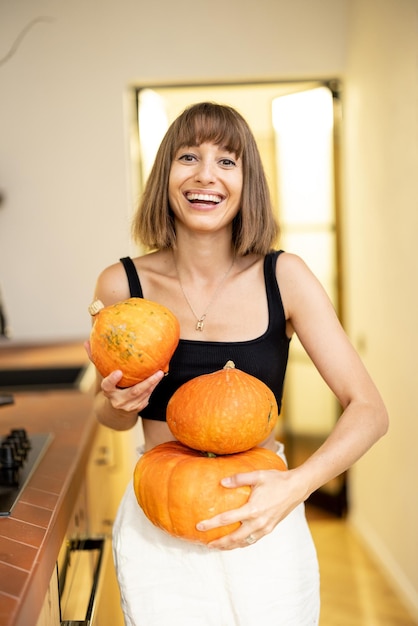 Mulher com abóboras na cozinha