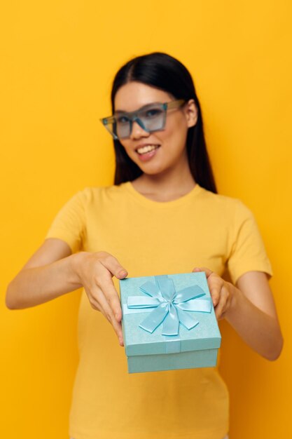 Mulher com aparência asiática camiseta amarela caixa de presente de aniversário fundo isolado inalterado