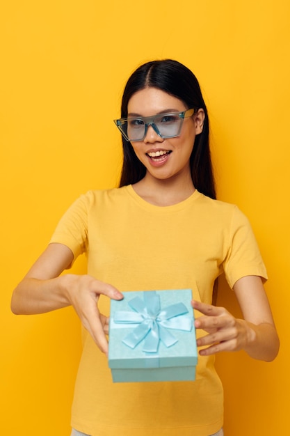 Mulher com aparência asiática camiseta amarela caixa de presente de aniversário fundo isolado inalterado