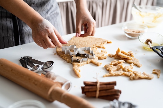 Mulher com as mãos assando biscoitos na cozinha