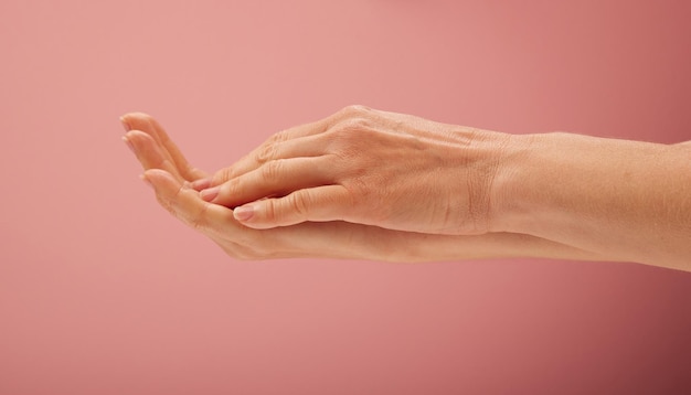 Mulher com as mãos no fundo rosa para conceitos de beleza