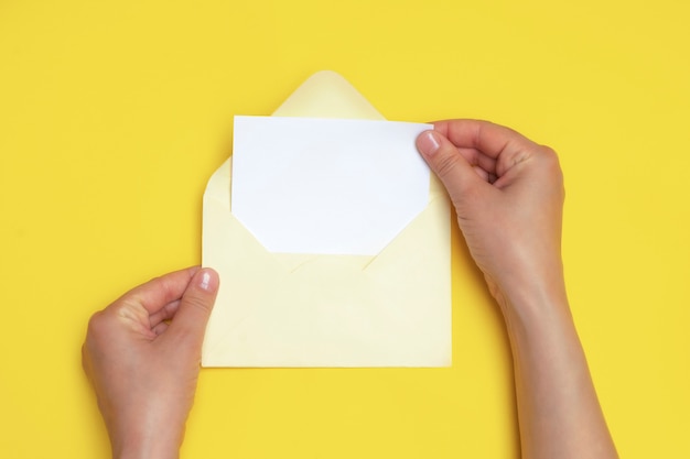 Foto mulher com as mãos segurando um envelope aberto com cartão branco em branco