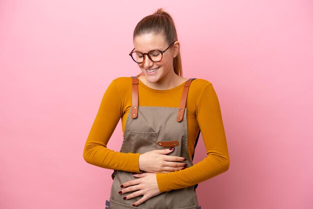 Foto mulher com avental isolado no fundo rosa sorrindo muito