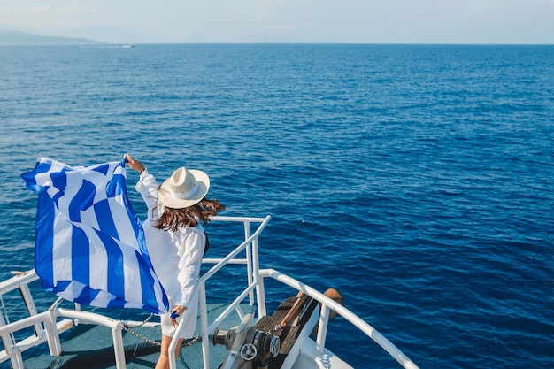 Mulher com bandeira da grécia na ilha de lefkada de barco de cruzeiro