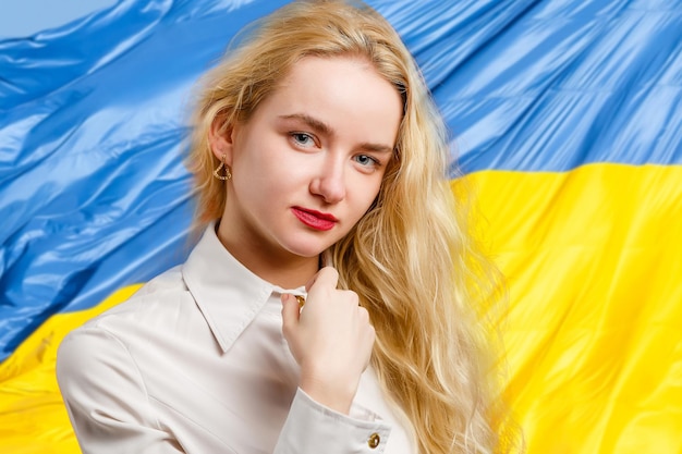 Mulher com bandeira da Ucrânia ao fundo olhando para a câmera Conceito de ficar com a nação ucraniana em guerra com a Rússia