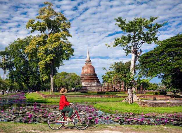 Foto mulher com bicicleta perto do templo na tailândia