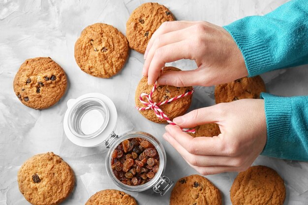 Mulher com biscoitos de aveia na mesa