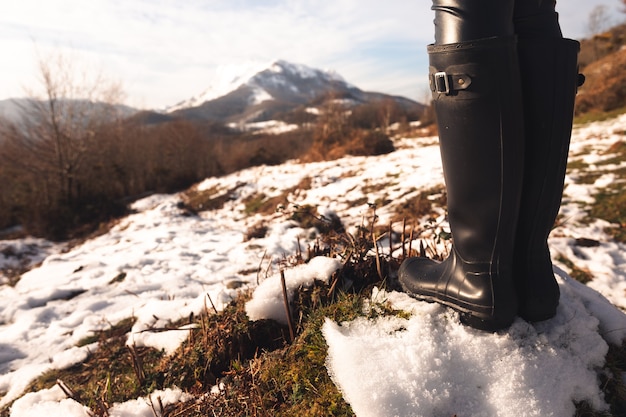 Mulher com botas altas em uma montanha de neve