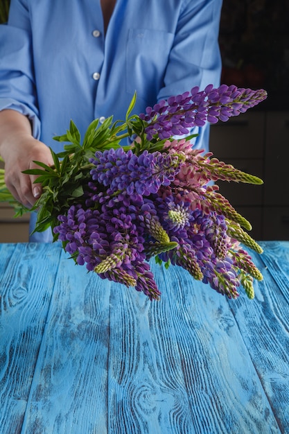 Mulher com buquê de flores silvestres de tremoço