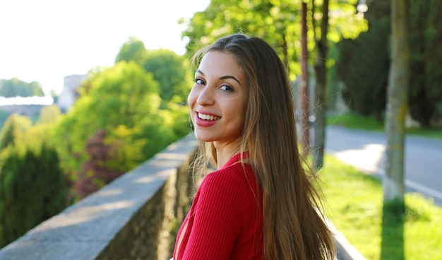 Mulher com cabelo comprido virando a cabeça e olhando para a câmera