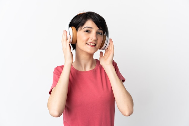 Mulher com cabelo curto sobre uma parede isolada ouvindo música