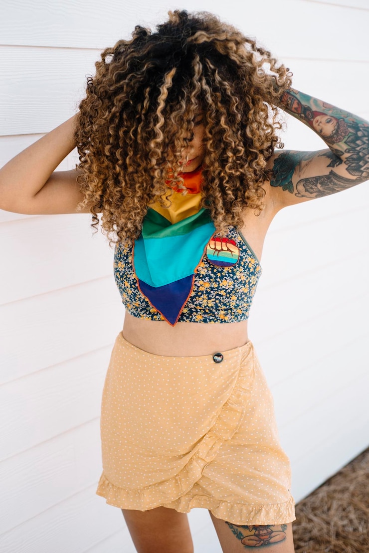 Foto mulher com cabelo encaracolado de pé contra a madeira