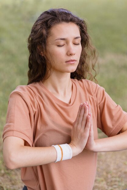 Mulher com cabelo encaracolado medita em um parque de ioga e meditação para saúde mental e física