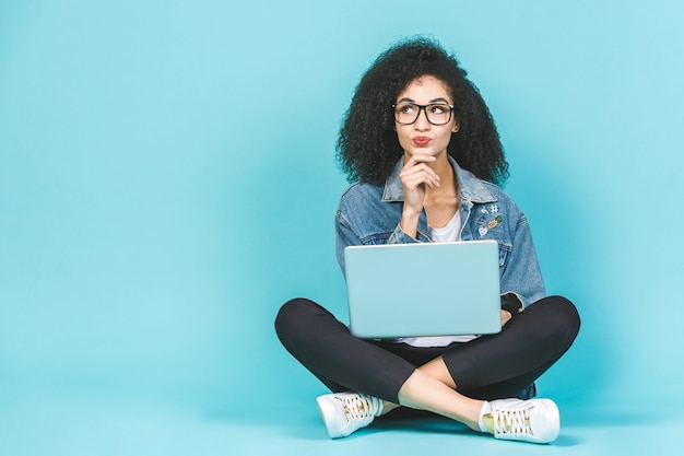 Mulher com cabelo encaracolado segurando um laptop