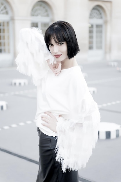 Mulher com cabelo moreno curto elegante e lábios vermelhos. Garota de blusa elegante. Beleza e moda vintage. Pose de modelo de moda no fundo da rua. Look e estilo retrô.