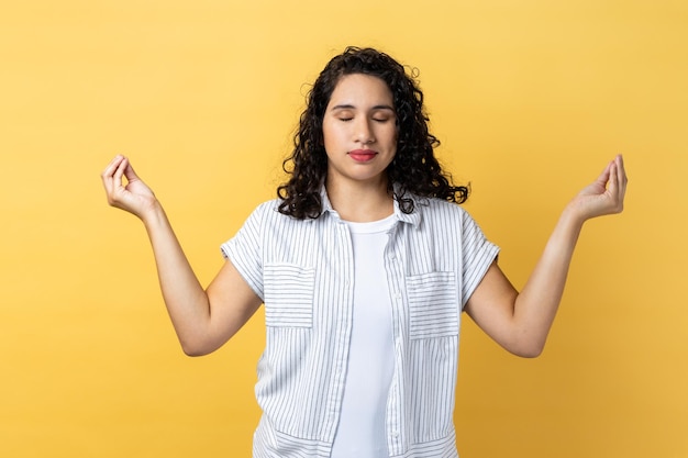 Mulher com cabelo ondulado escuro, sentindo-se calma e relaxada com a prática de ioga mental pacífica