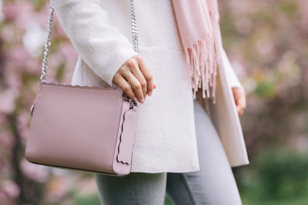 Mulher com cachecol de jaleco branco e bolsa rosa