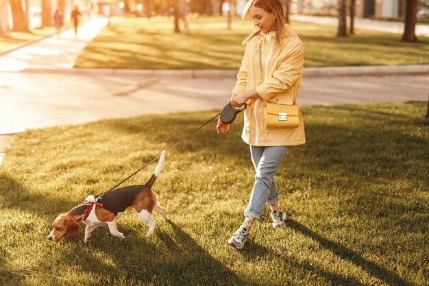 Mulher com cachorro andando no gramado verde