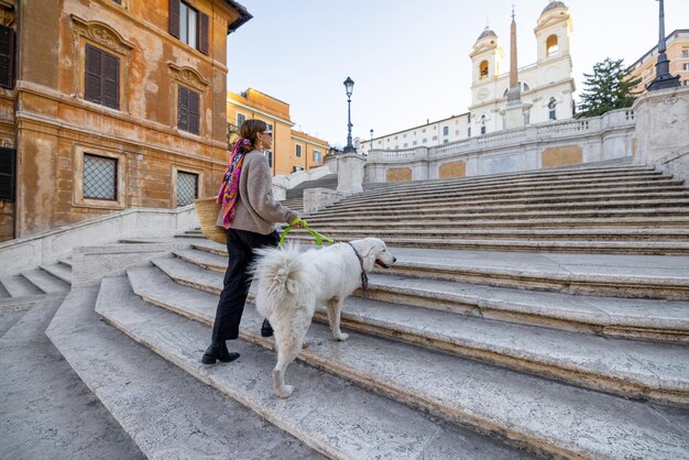 Mulher com cachorro na famosa escadaria espanhola na cidade de roma