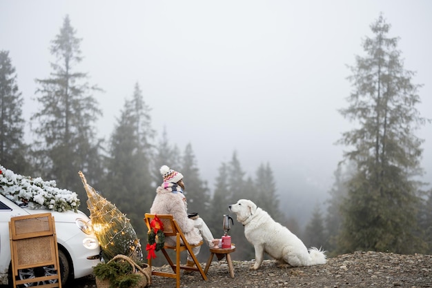 Mulher com cachorro nas montanhas nas férias de inverno