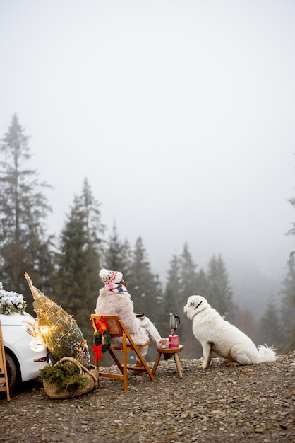 Mulher com cachorro nas montanhas nas férias de inverno