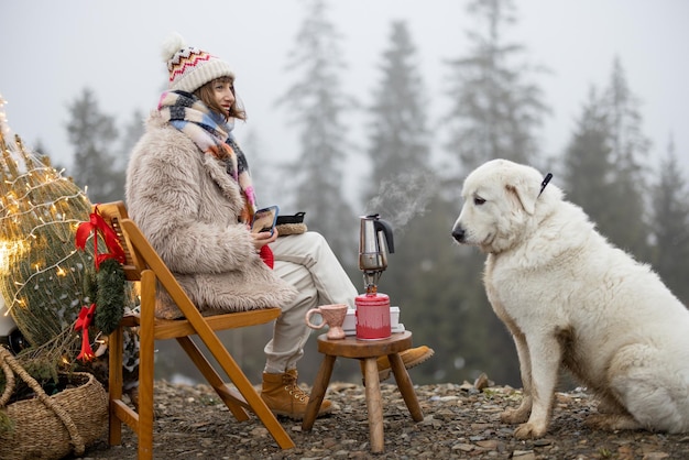 Mulher com cachorro nas montanhas nas férias de inverno