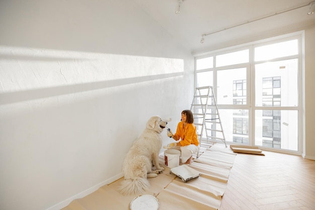 Mulher com cachorro no quarto enquanto faz reparos no apartamento