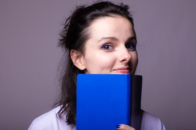 mulher com caderno azul nas mãos