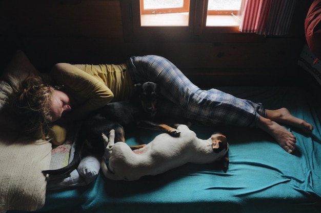 Mulher com cães relaxando na cama