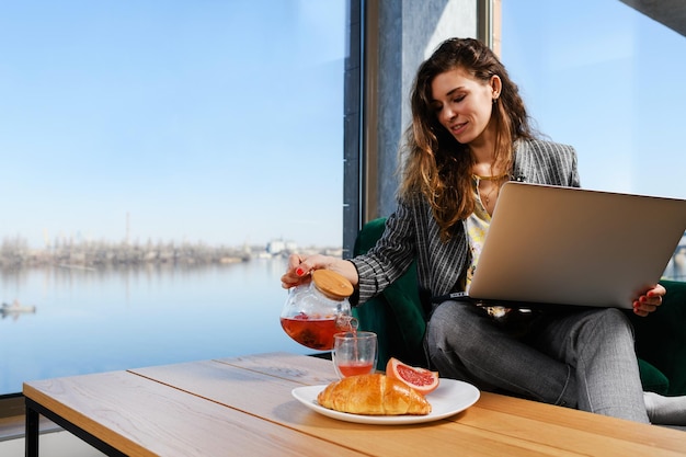 Mulher com café da manhã portátil e bela vista