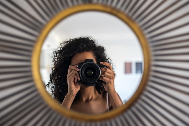 Mulher com câmera tirando foto de reflexão