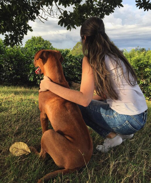 Foto mulher com cão em paisagem