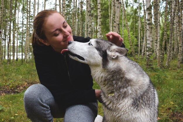 Foto mulher com cão na floresta