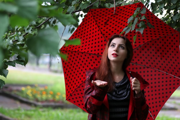 Mulher com capa de chuva e guarda-chuva