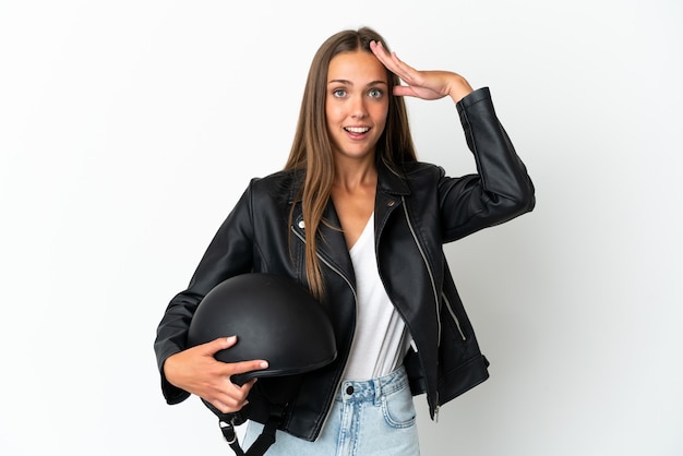 Mulher com capacete de motociclista sobre fundo branco isolado com expressão de surpresa