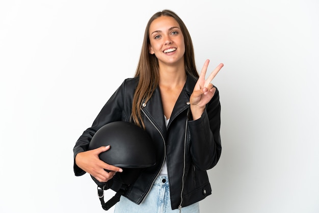 Mulher com capacete de motociclista sobre fundo branco isolado sorrindo e mostrando sinal de vitória