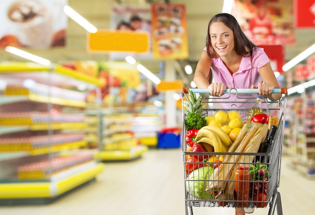 Mulher com carrinho de compras no supermercado