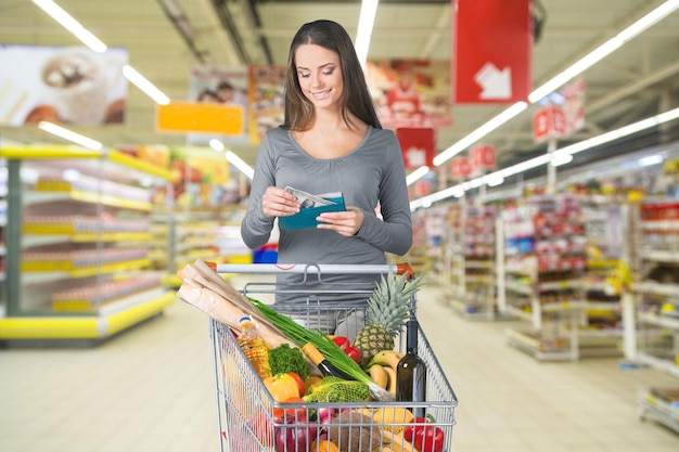 Foto mulher com carrinho de compras no supermercado