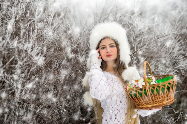 Mulher com cestas no parque de neve de inverno