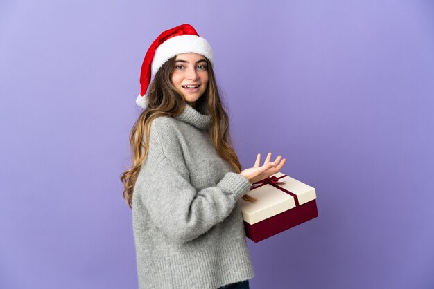 mulher com chapéu de natal segurando presentes