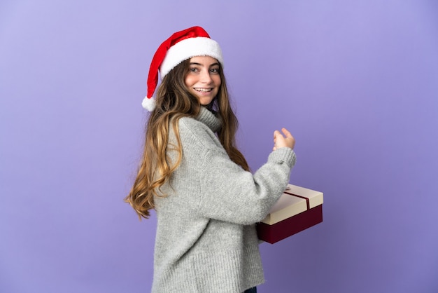 Mulher com chapéu de natal segurando presentes