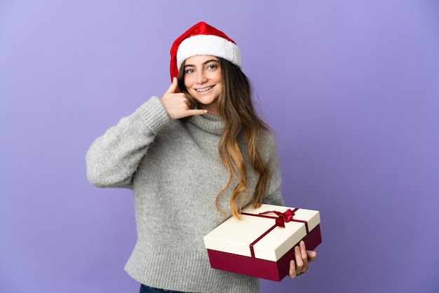 mulher com chapéu de natal segurando presentes