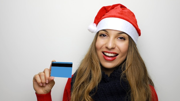 Mulher com chapéu de Papai Noel e cartão de crédito em branco