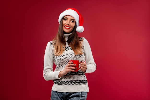 Mulher com chapéu de Papai Noel vermelho